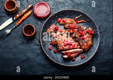 Bistecca di maiale con salsa di frutti di bosco. Foto Stock