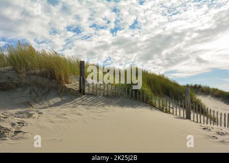 Duna di sabbia con erba spiaggia e una recinzione di legno Foto Stock