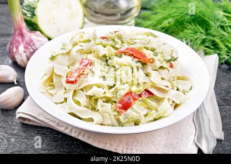 Fettuccine con zucchine e peperoni in piatto a bordo Foto Stock