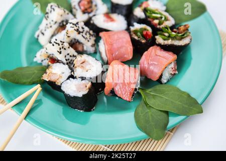 Vari tipi di maki sushi, philadelphia, maki, salmone, riso, insalata. Cibo delizioso e sano. Primo piano. Foto Stock