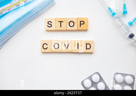 Stop incoronavirus iscrizione. Preparazione per la vaccinazione contro il covid-19. Siringa, vaccino, pillole, maschera medica. Foto Stock