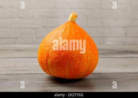 Red kuri squash (Hokaido zucca) grigio sulla tavola di legno. Foto Stock