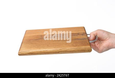 le mani femminili tengono il tagliere di legno rettangolare marrone vuoto su sfondo bianco Foto Stock