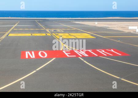 nessun cartello d'ingresso sulla pista dell'aeroporto con l'oceano sullo sfondo Foto Stock