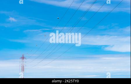 Linee elettriche ad alta tensione contro il cielo blu. Torre di trasmissione elettrica ad alta tensione. Traliccio elettrico e linee di trasmissione di energia elettrica. La torre ad alta tensione fornisce alimentazione. Potenza ed energia. Foto Stock