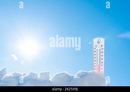 Il termometro si trova sulla neve in inverno mostrando una temperatura negativa. Condizioni meteorologiche in un clima rigido in inverno con aria bassa e temperature ambiente.congelare in inverno.Sunny inverno Foto Stock