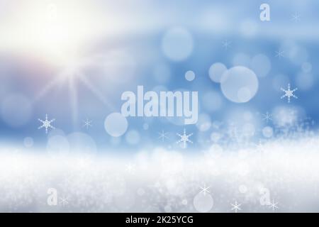 Astratto sfocato Natale di inverno festivo o felice sfondo di Capodanno con blu lucido e bianco bokeh illuminato paesaggio di neve con cielo e sole. Spazio. Foto Stock