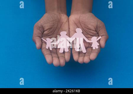 Vista dall'alto dell'intaglio della famiglia con presa a mano. Giornata mondiale della salute protezione contro la violenza domestica, l'assistenza sanitaria e il background medico. Promuovere l'assistenza, il sostegno ai senzatetto e il concetto di allontanamento sociale. Foto Stock