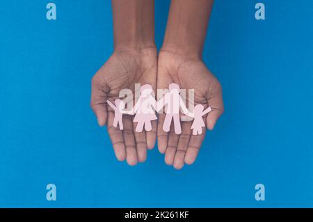 Vista dall'alto dell'intaglio della famiglia con presa a mano. Giornata mondiale della salute protezione contro la violenza domestica, l'assistenza sanitaria e il background medico. Promuovere l'assistenza, il sostegno ai senzatetto e il concetto di allontanamento sociale. Foto Stock