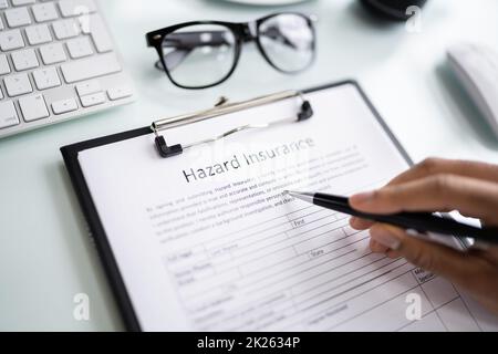 Uomo che compila il modulo di assicurazione pericolo Foto Stock