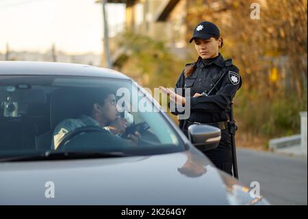 L'ufficiale di polizia femminile rifiuta la tangente dal conducente Foto Stock