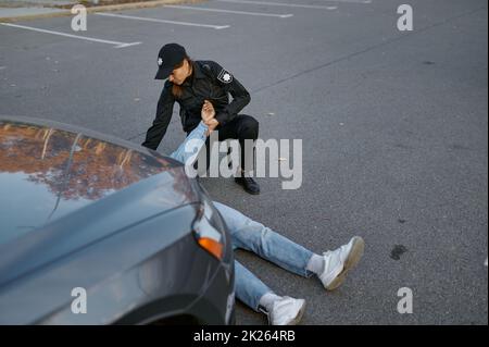 Poliziotto di controllo impulso della vittima di incidente auto Foto Stock