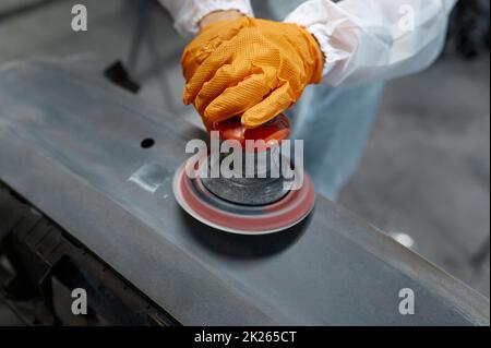 Primo piano mani meccaniche auto con lucidatrice orbitale Foto Stock