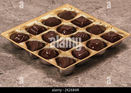 Cioccolatini assortiti in una scatola dorata Foto Stock