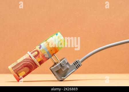 Spina elettrica con banconote in euro Foto Stock