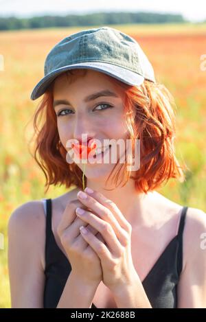 ragazza con fiori di papavero in campo papavero Foto Stock