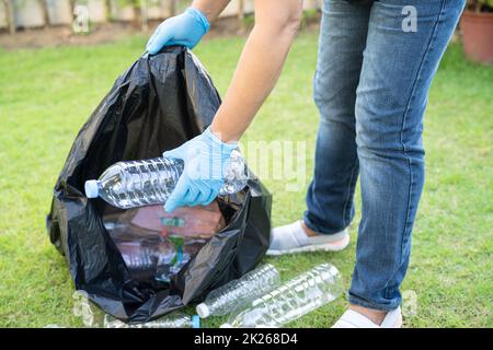 Donna asiatica volontario trasportare bottiglie di plastica di acqua in sacchetto di rifiuti rifiuti rifiuti in parco, riciclare ambiente ecologia concetto. Foto Stock