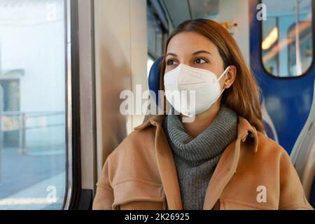 Donna d'affari che indossa una maschera protettiva mentre viaggia con i mezzi pubblici Foto Stock