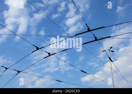 Tram / tram tram linea elettrica aerea contro il cielo blu. Foto Stock