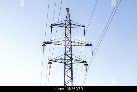 Linee elettriche ad alta tensione, palo o torre sullo sfondo di un bel cielo. Ordini sequenziali di piloni ad alta energia. Foto Stock