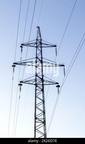 Linee elettriche ad alta tensione, palo o torre sullo sfondo di un bel cielo. Ordini sequenziali di piloni ad alta energia. Foto Stock