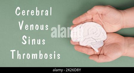 La trombosi venosa cerebrale del Sinus è in piedi su una carta, le mani che tengono un cervello, danno di vaccino, covid-19 Foto Stock