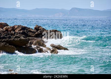 Rocce sulla riva colpite dall'onda Foto Stock