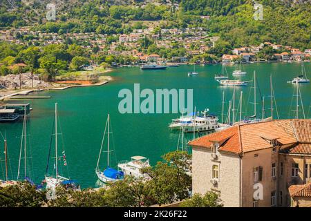 Paesaggio colorato con barche in marina baia, mare, montagne, cielo blu. Vista dall'alto della baia di Cattaro, Montenegro Foto Stock