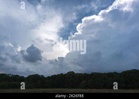 Grandi nubi di tempesta sopra la campagna si accumulano e portano vento e pioggia pesante Foto Stock