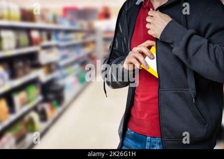 Taccheggio al dettaglio. Uomo che ruba in supermercato Foto Stock