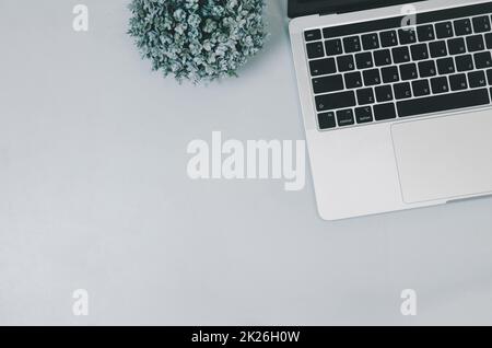 Vista dall'alto, computer portatile e fiore sul tavolo. Spazio per la copia Foto Stock