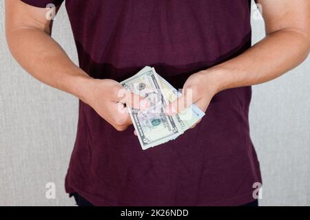 l'uomo tiene in mano una bacchetta di dollari. Dollari USA Foto Stock