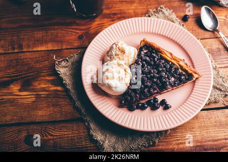 Fetta di torta di serviceberry e due cucchiai di gelato alla vaniglia Foto Stock