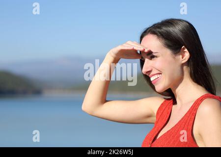 Donna che copre gli occhi una giornata di sole alla ricerca della natura Foto Stock