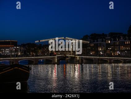 De magere brug o 'skinny bridge' di notte, Amsterdam Foto Stock