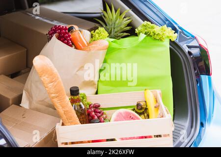 Servizio di alimentari con verdure fresche in cesto di legno sul retro auto Foto Stock