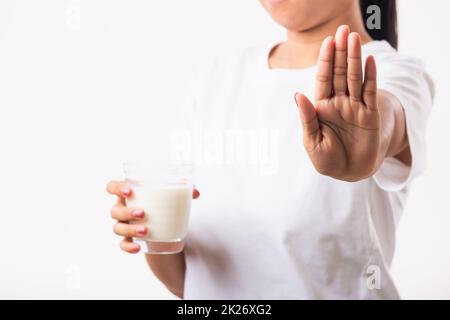 Donna alza una mano per fermare l'uso segno mano che tiene il latte di vetro lei è mal di stomaco ha cattivo lattosio Foto Stock