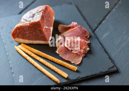 Prosciutto italiano servito con grissini Foto Stock