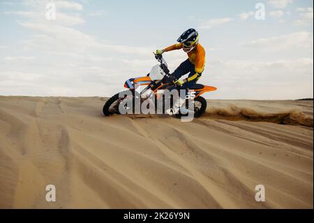 Rider che fa acrobazie su moto sliding sabbia Foto Stock