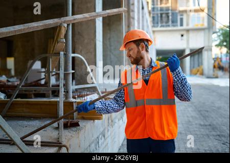 Appaltatore che lavora con i raccordi in cantiere Foto Stock