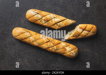 Baguette arrosto con burro all'aglio. Pane all'aglio croccante a fette sul tavolo nero. Foto Stock