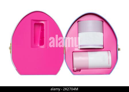 Primo piano di una scatola cosmetica decorativa aperta o scatola regalo con contenitori bianchi rosa senza etichette isolati su sfondo bianco. Macro. Foto Stock