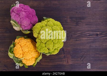 Freschi fiori di cavolfiore colorato su un legno rustico Foto Stock