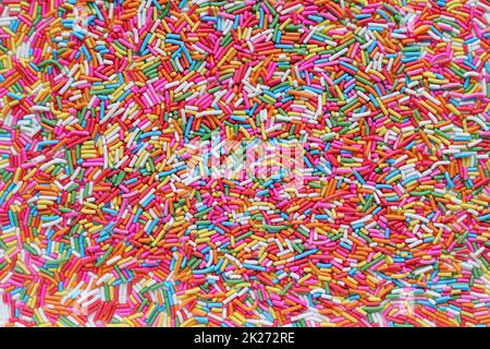 Un sacco di sfondo di granuli di zucchero dai colori vivaci utilizzato per la condimenti di dessert, cupcake e gelato in Top View è uno sfondo colorato adatto f Foto Stock