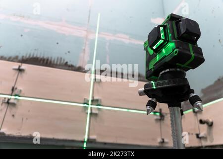 Costruzione e riparazione di pareti in un nuovo building.posing piastrelle da parete utilizzando un livello di costruzione e una livella laser. Ristrutturazione della casa. Eseguire calcoli e misurazioni utilizzando un laser Foto Stock