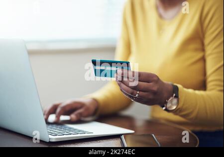 Il sabato sono giornate autosostanti. Scatto corto di una donna irriconoscibile seduta da sola a casa e utilizzando il suo laptop per lo shopping online. Foto Stock