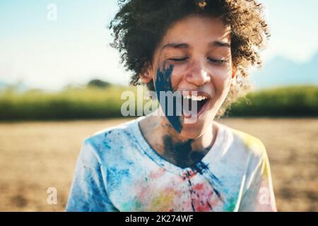 Il dolore può esplodere. Scatto di un ragazzo adolescente che si diverte con la polvere colorata al campo estivo. Foto Stock