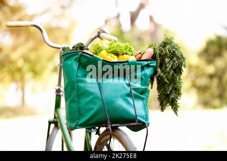 Cibo sano ed esercizio fisico. Immagine ritagliata di una borsa di oggetti vegatables su una bicicletta. Foto Stock