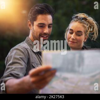 Abbiamo così tante opzioni. Scatto di una giovane coppia utilizzando una mappa durante l'esplorazione della città. Foto Stock