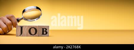 Mano della persona che guarda i blocchi di lavoro attraverso la lente d'ingrandimento Foto Stock